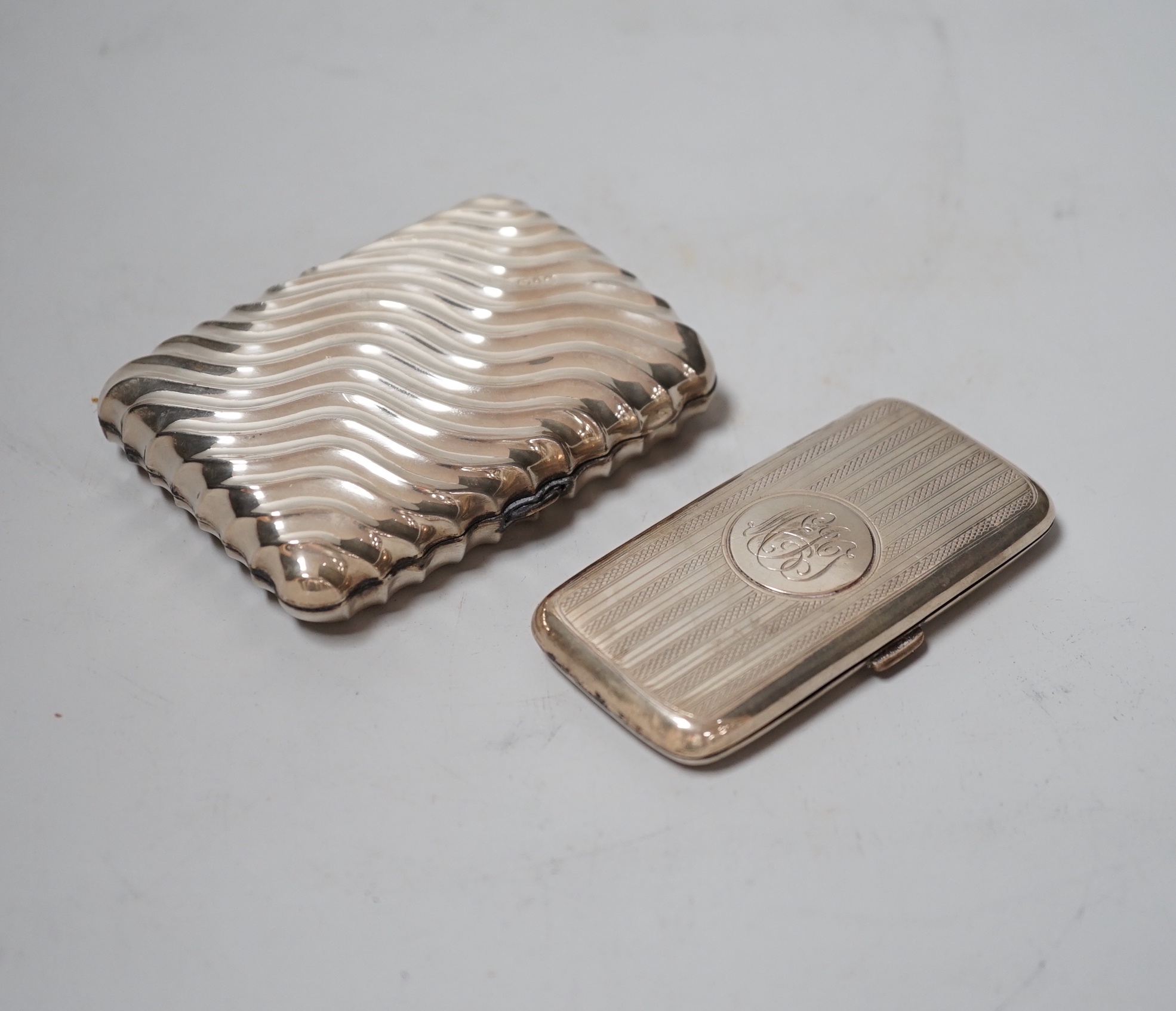 A late Victorian wrythened silver cigarette case, 88mm and a smaller silver cigarette case.